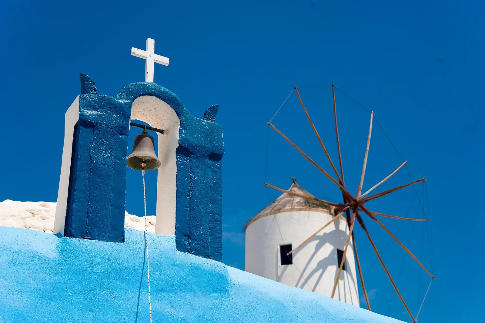 Blue bell tower and windmill in Oia, Santorini