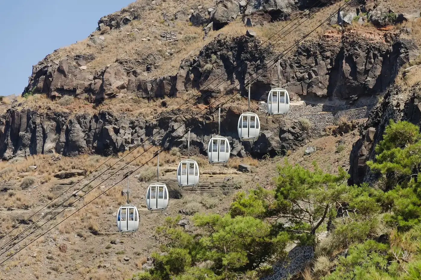 Cable cars climbing the cliff between the old port and Fira